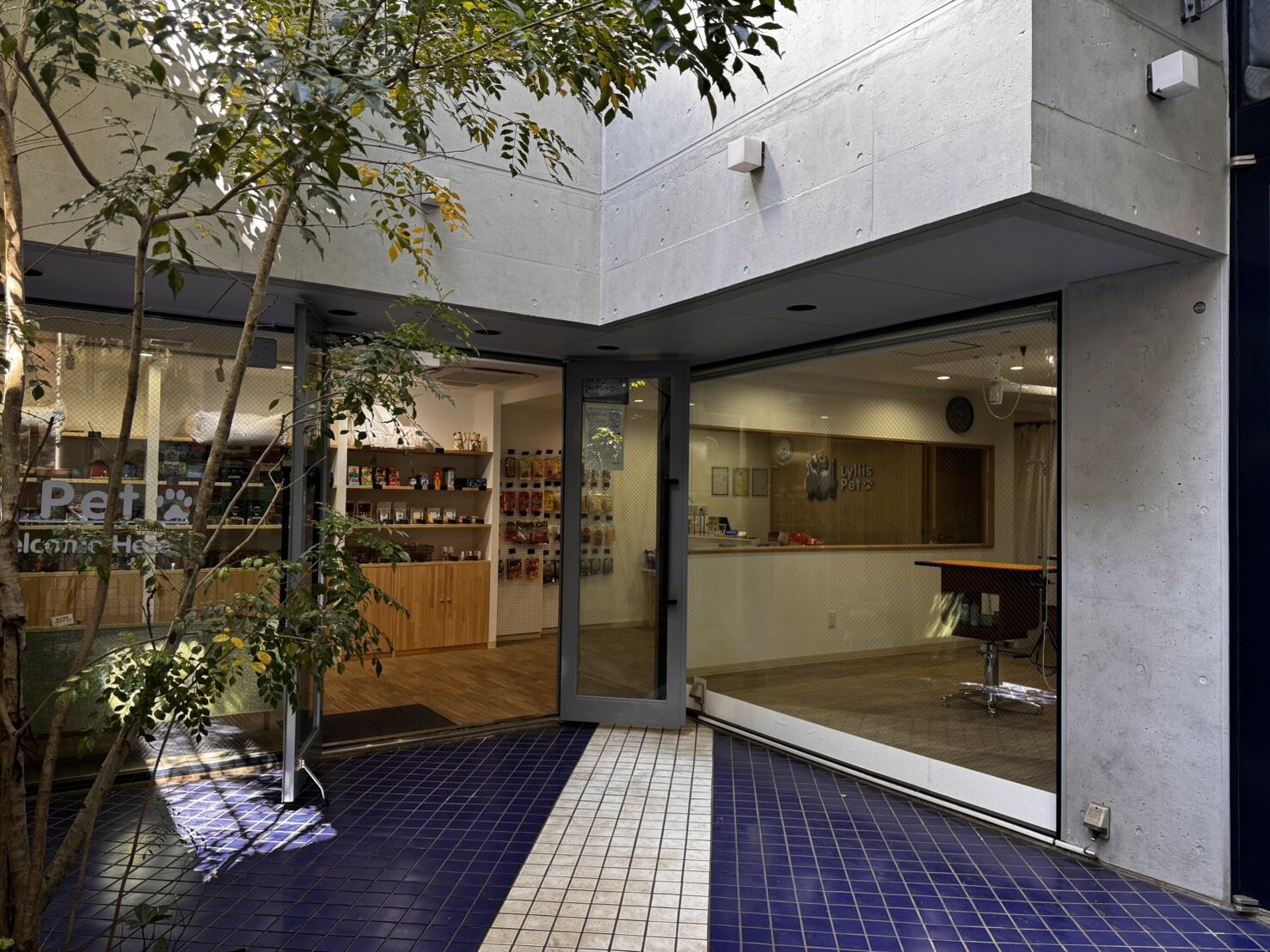 緑に囲まれたLyllis Pet Salonの店舗入口